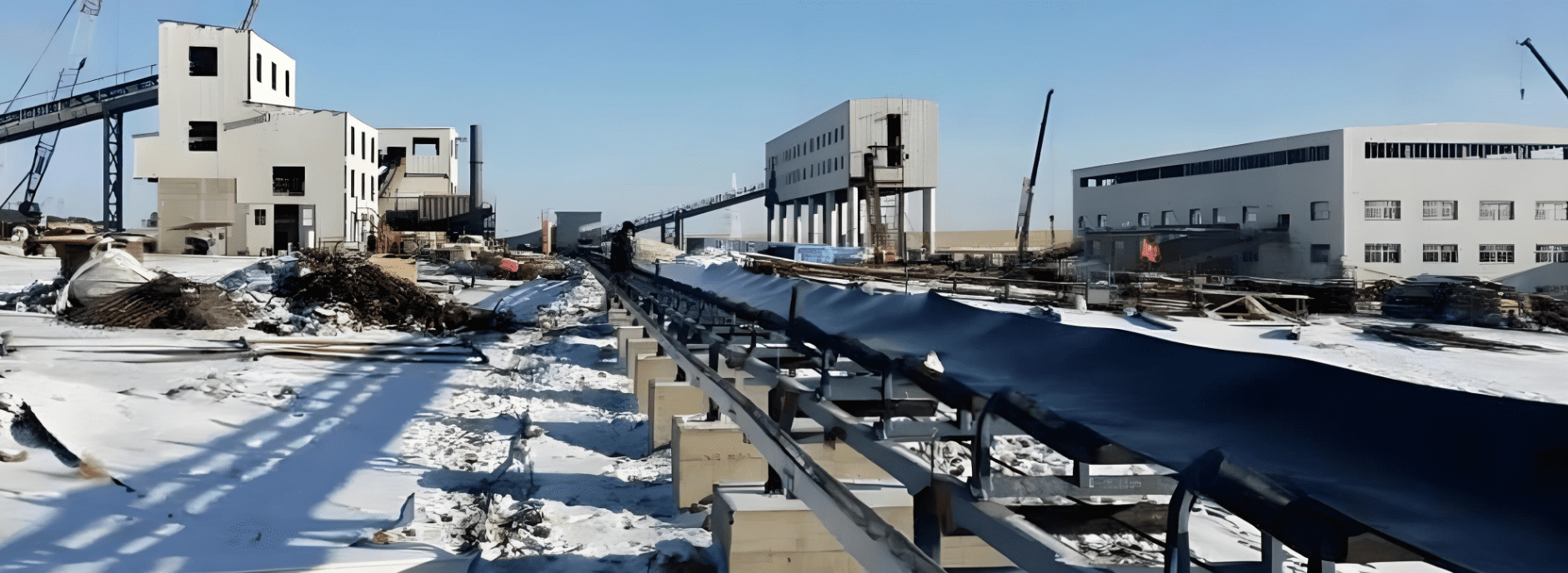 A DTII belt conveyor traverses a snowy area, illustrating its operational capability in challenging weather.