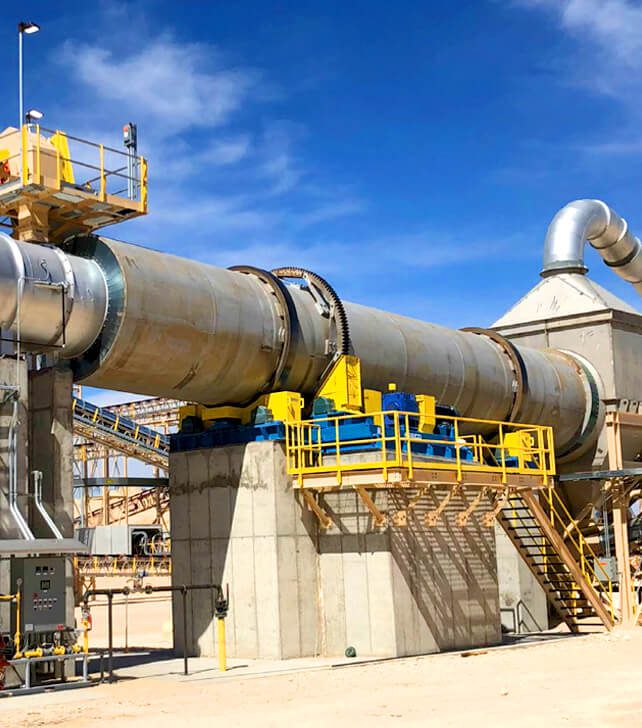 In the factory, the rotary kiln stands prominently, a robust structure ready for processing raw materials into clinker.